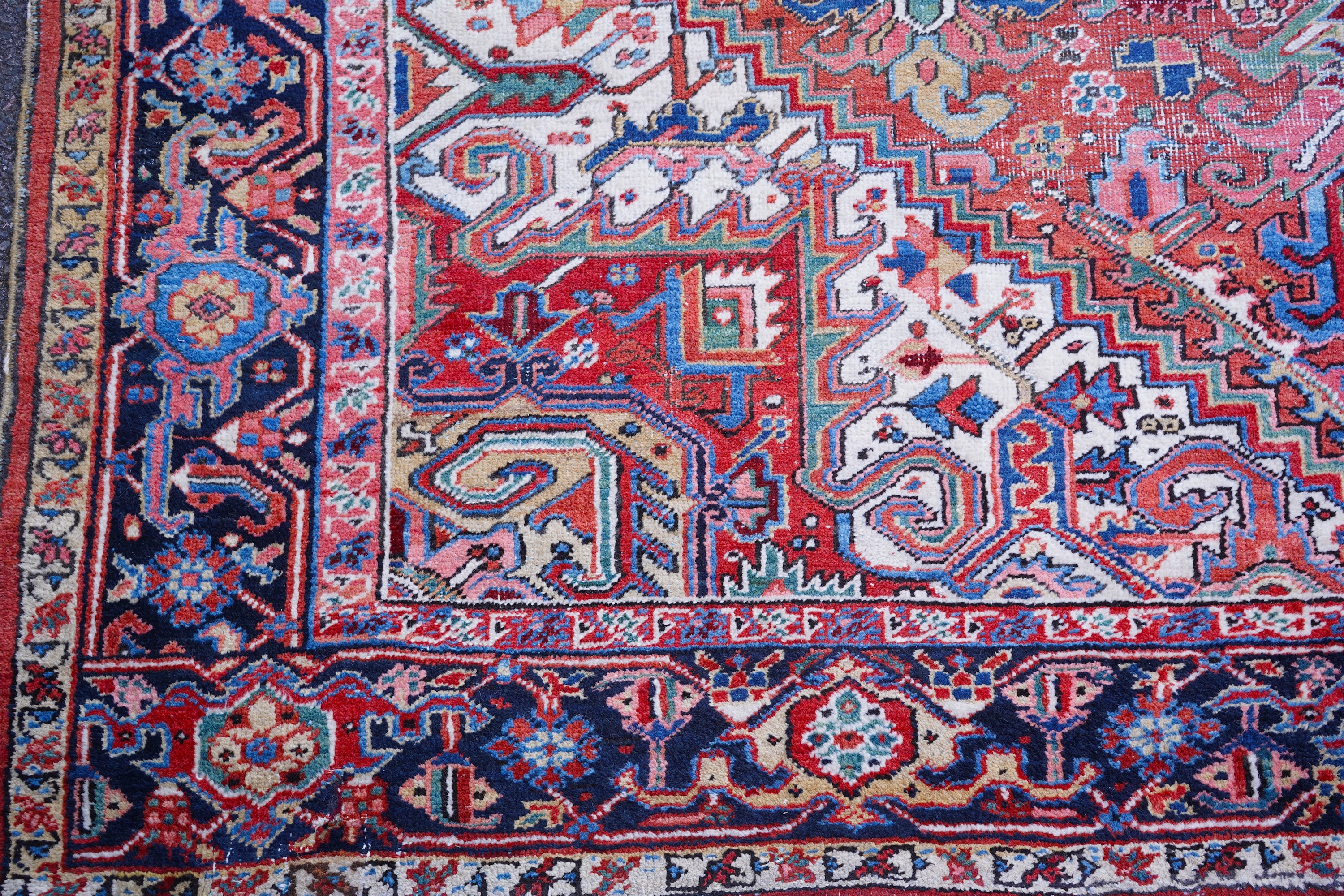 An antique Heriz brick red ground carpet with central